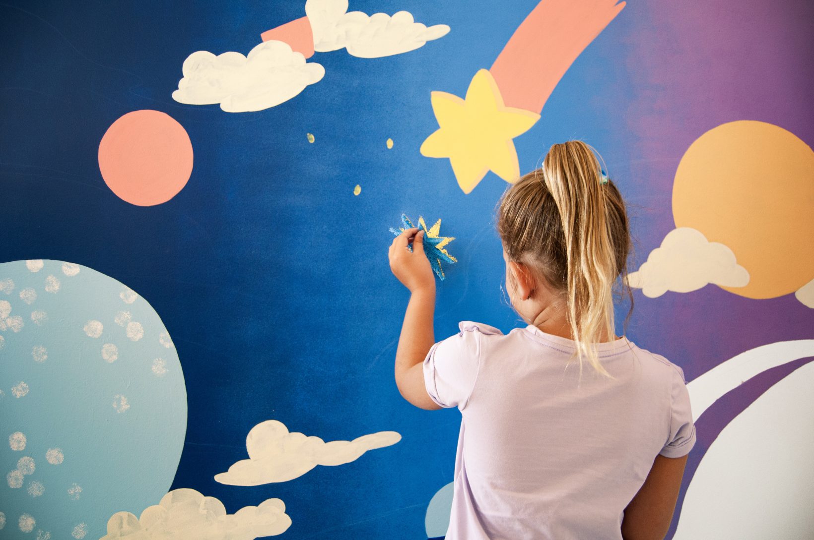 Girl sticking her sponge star to the wall